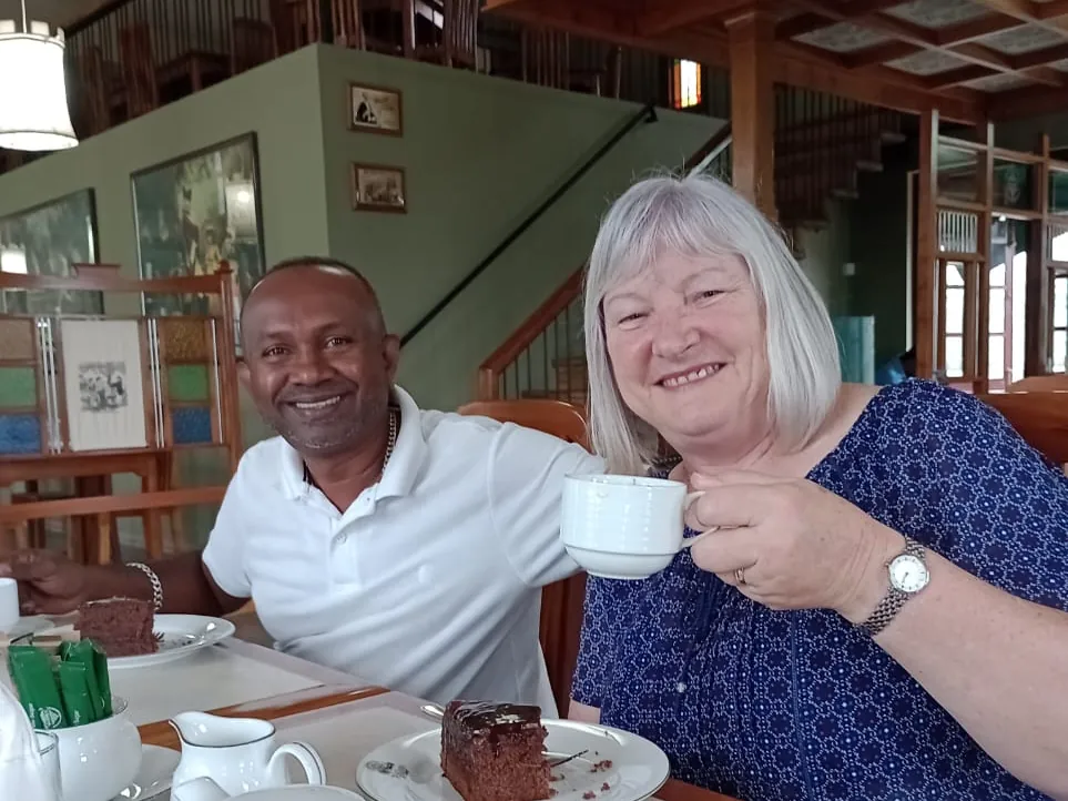 Reiseleiter Romesh genießt mit einem weiblichen Reisegast Tee und Kuchen während einer Rundreise durch Sri Lanka.